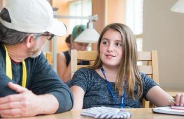 Child and teacher sitting at table chatting